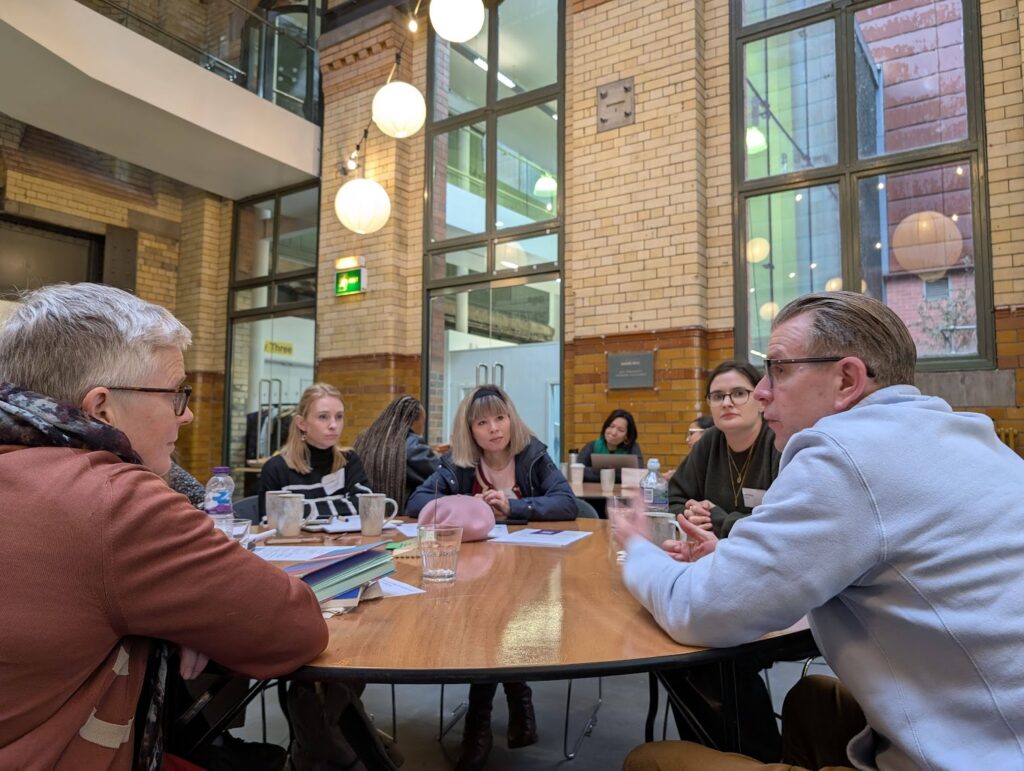Photo of five people around a table during the stakeholder speed-dating activity.